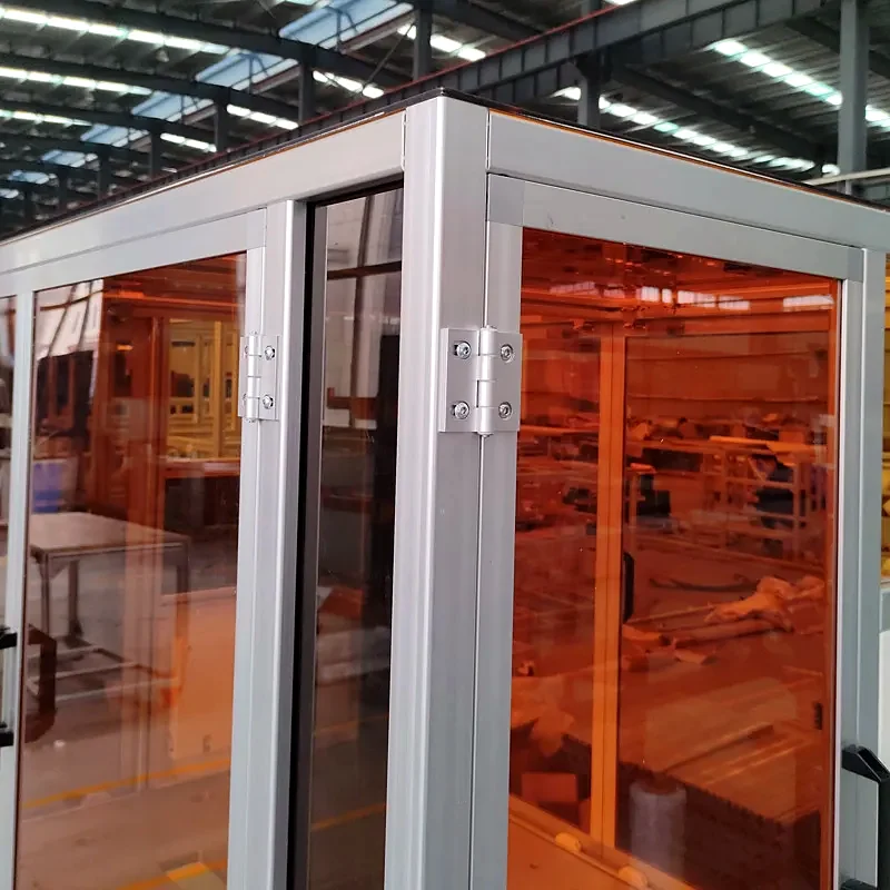 Aluminium machine enclosure with orange transparent panels and access doors.